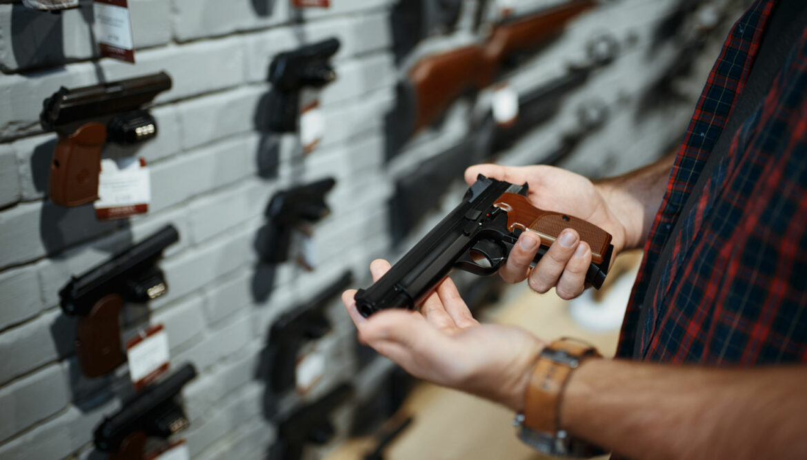 Hands holding gun at gun shop