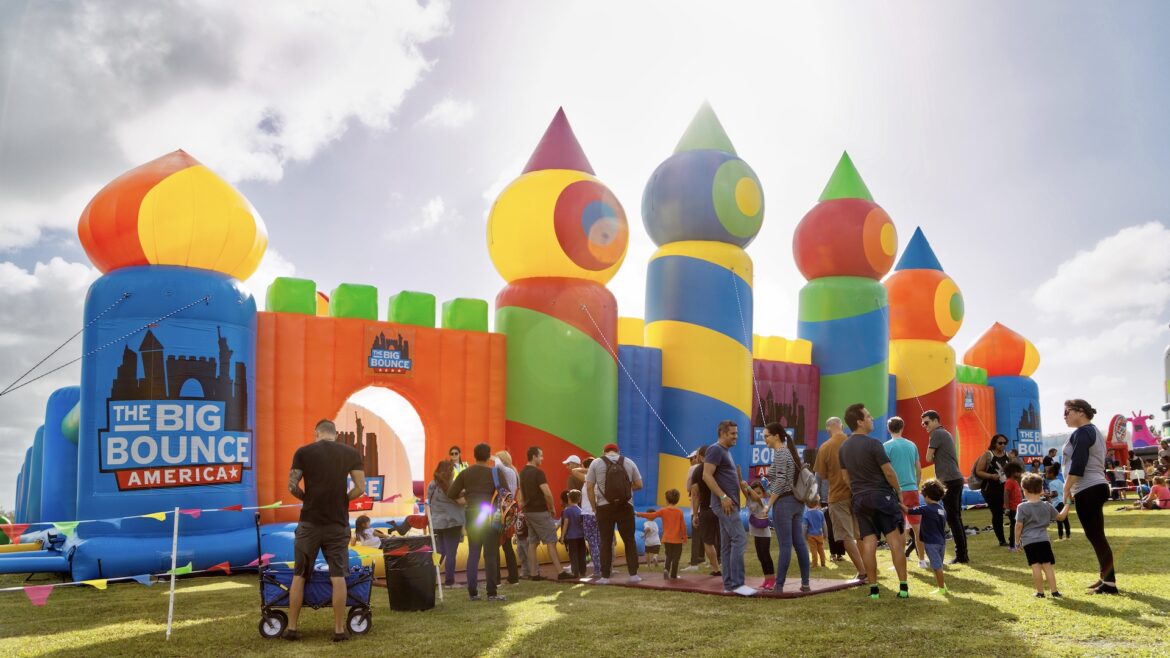 A huge inflatable bounce house with a line of people waiting to enter.