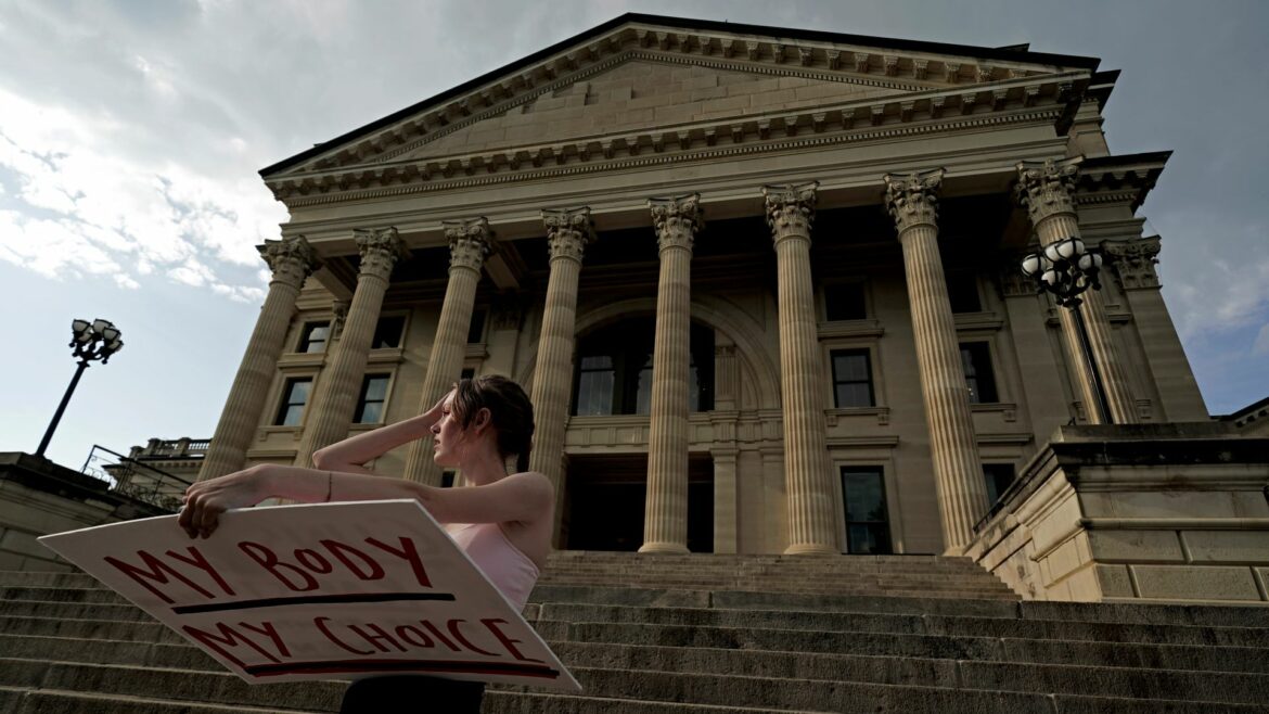 Zoe Schell, from Topeka, Kansas, stands on the steps of the Kansas Statehouse during a rally to protest the Supreme Court's ruling on abortion Friday, June 24, 2022, in Topeka.