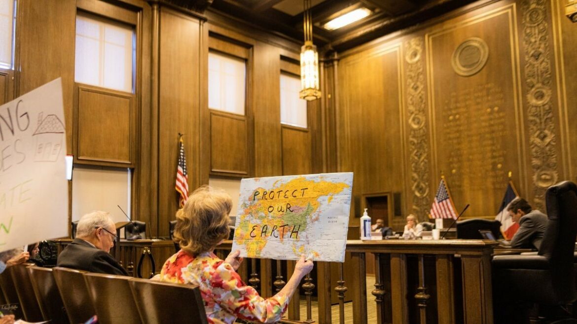 Activists sit inside City Hall on July 13, while the Neighborhood Planning and Development Committee deliberates on updating building codes. Groups like the Sierra Club and Sunrise Movement have been prominent during these meetings.