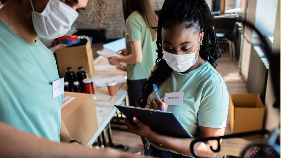 Volunteers sign a clipboard.