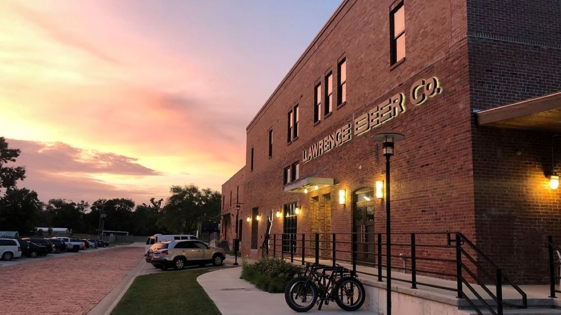 The exterior of Lawrence Beer Co. with the sunset in the background.