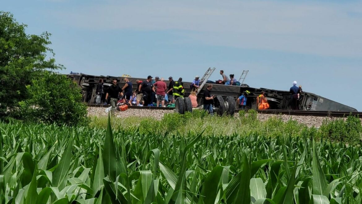 People outside of a crashed Amtrak train car.