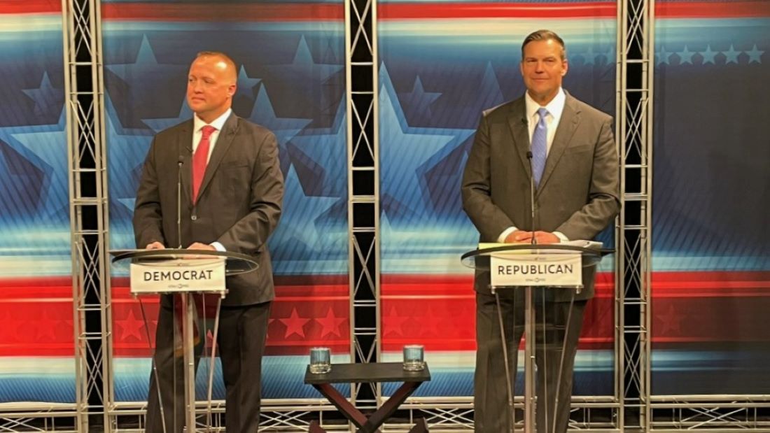 Democrat Chris Mann and Republican Kris Kobach on the debate stage.