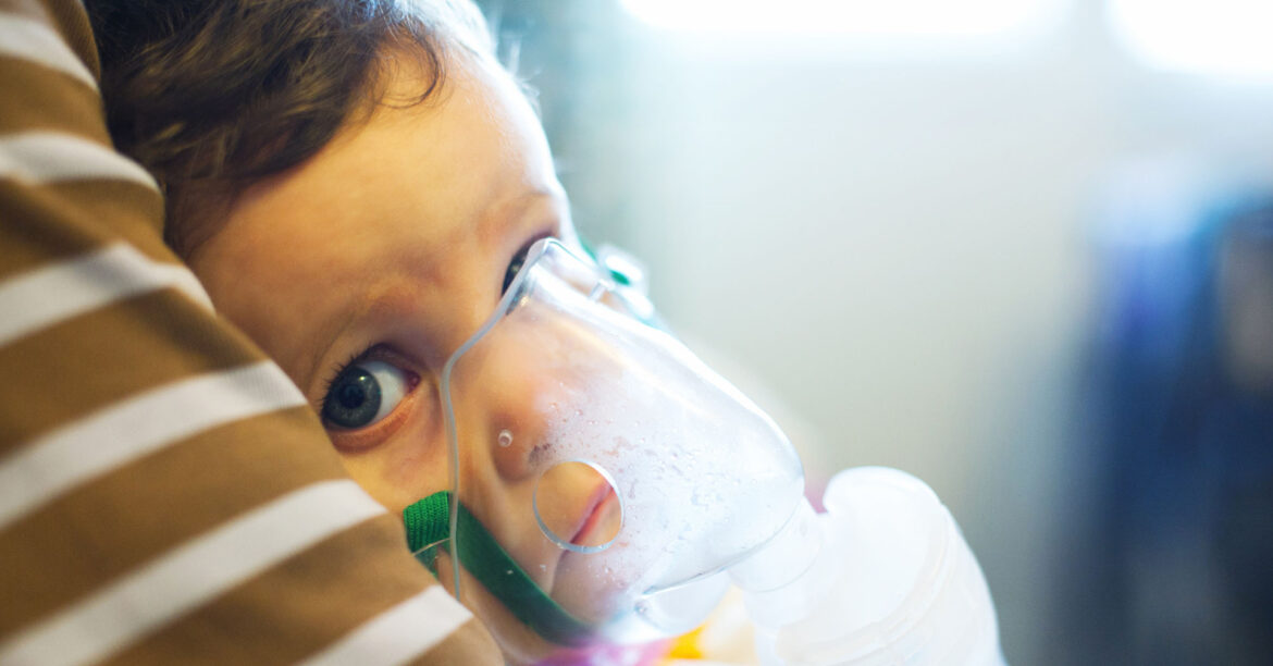A young child with a oxygen mask on looks into the camera. Pediatric health is taking a hit, in more ways than one parents and doctors say. (Adobe)