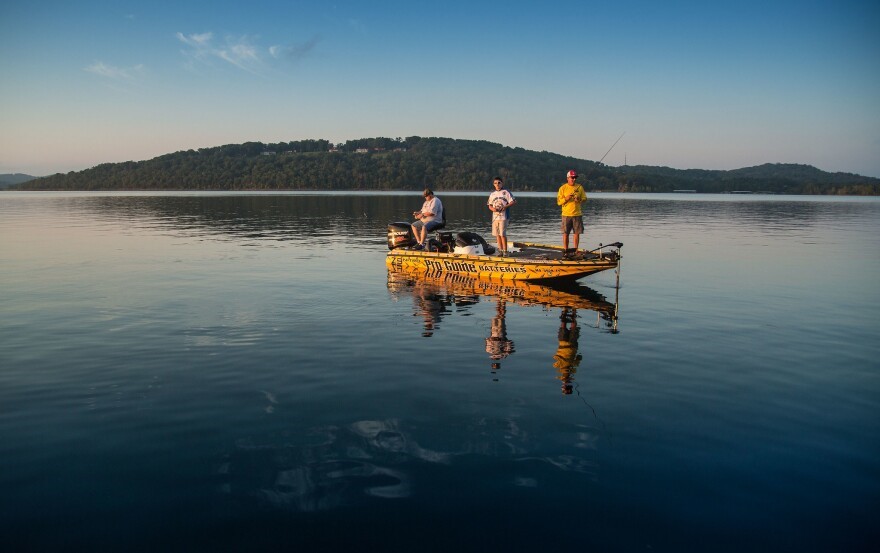 Three people fishing in a boat on Table Rock Lake.