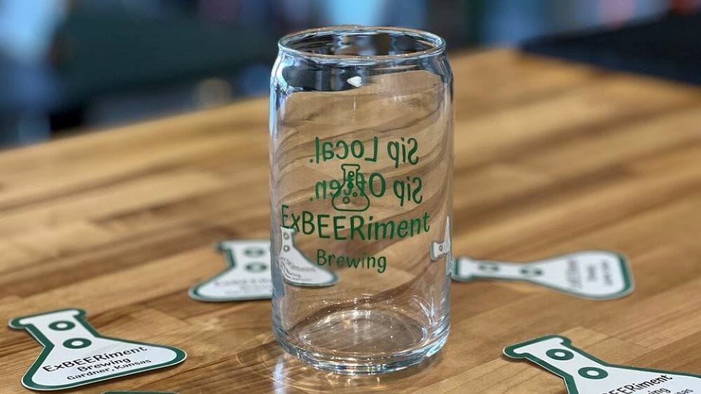 An ExBEERiment glass on a bar.