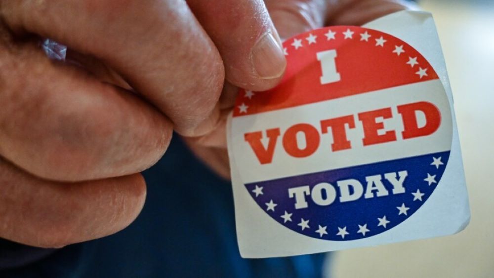 A man holding an "I Voted Today" sticker.
