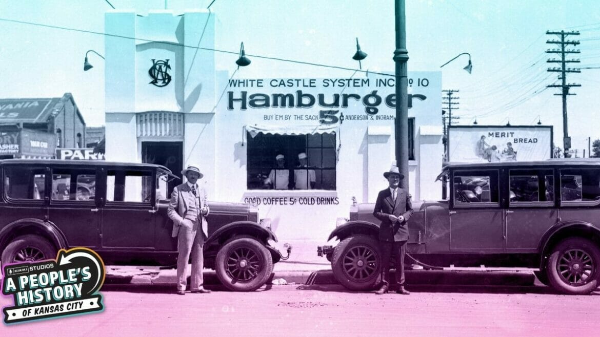 White Castle founders Walt Anderson and Billy Ingram stand next to two automobiles outside of White Castle number 10, located at 318 West Douglas Avenue in Wichita, Kansas. The sign on the building reads: "White Castle System, Inc. No. 10 - Hamburger - Buy 'em by the sack 5¢ Anderson and Ingram." Two employees can be seen posing in the window, which advertises "Good coffee 5¢ Cold drinks."