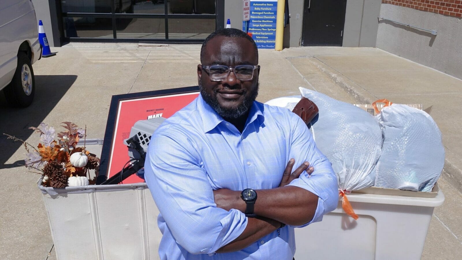 Funmi Popoola, President and CEO of Goodwill of Western Missouri & Eastern Kansas, leans against carts filled with donations.