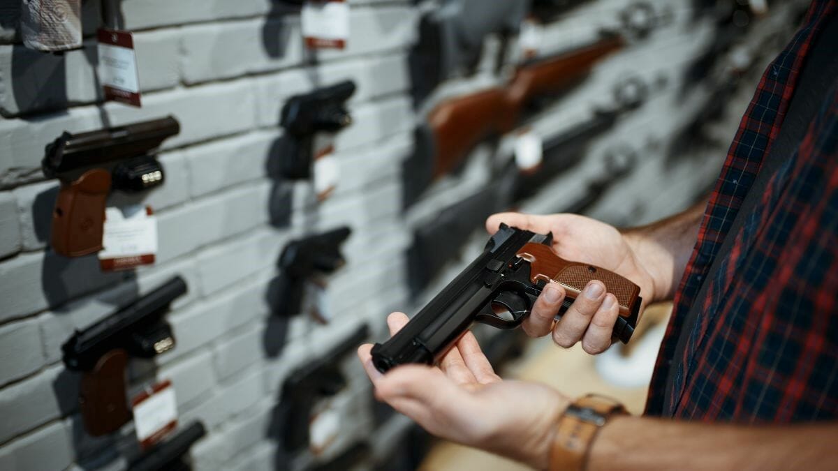 A man holds a handgun in a store.