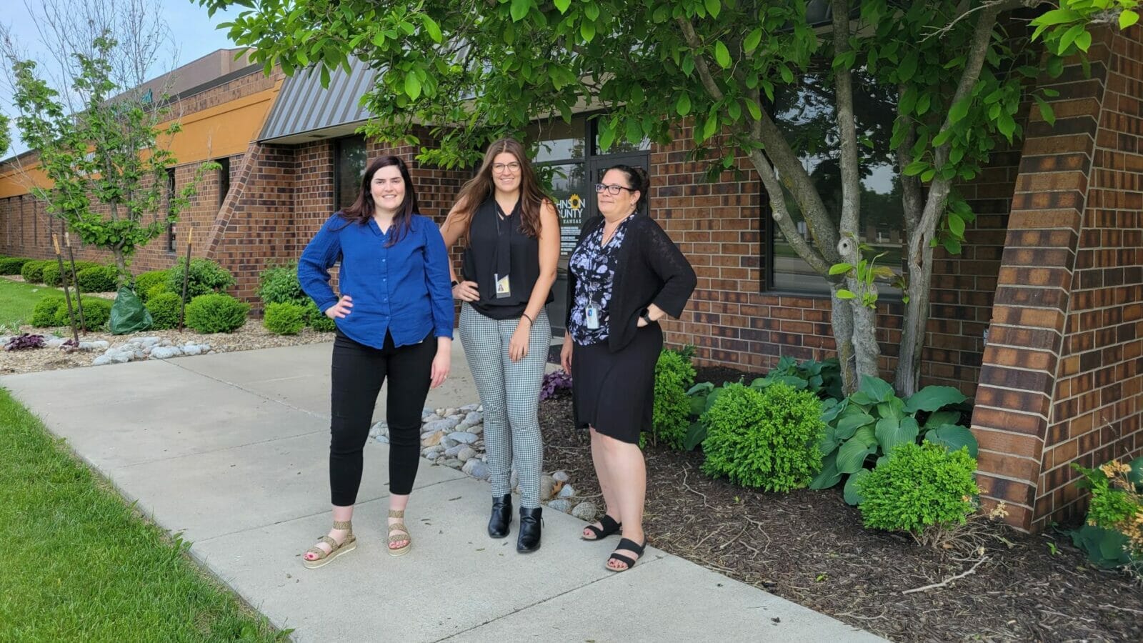 Heather McNeive, Jessa Molina and Teresa Spaeth standing in front of a brick building.