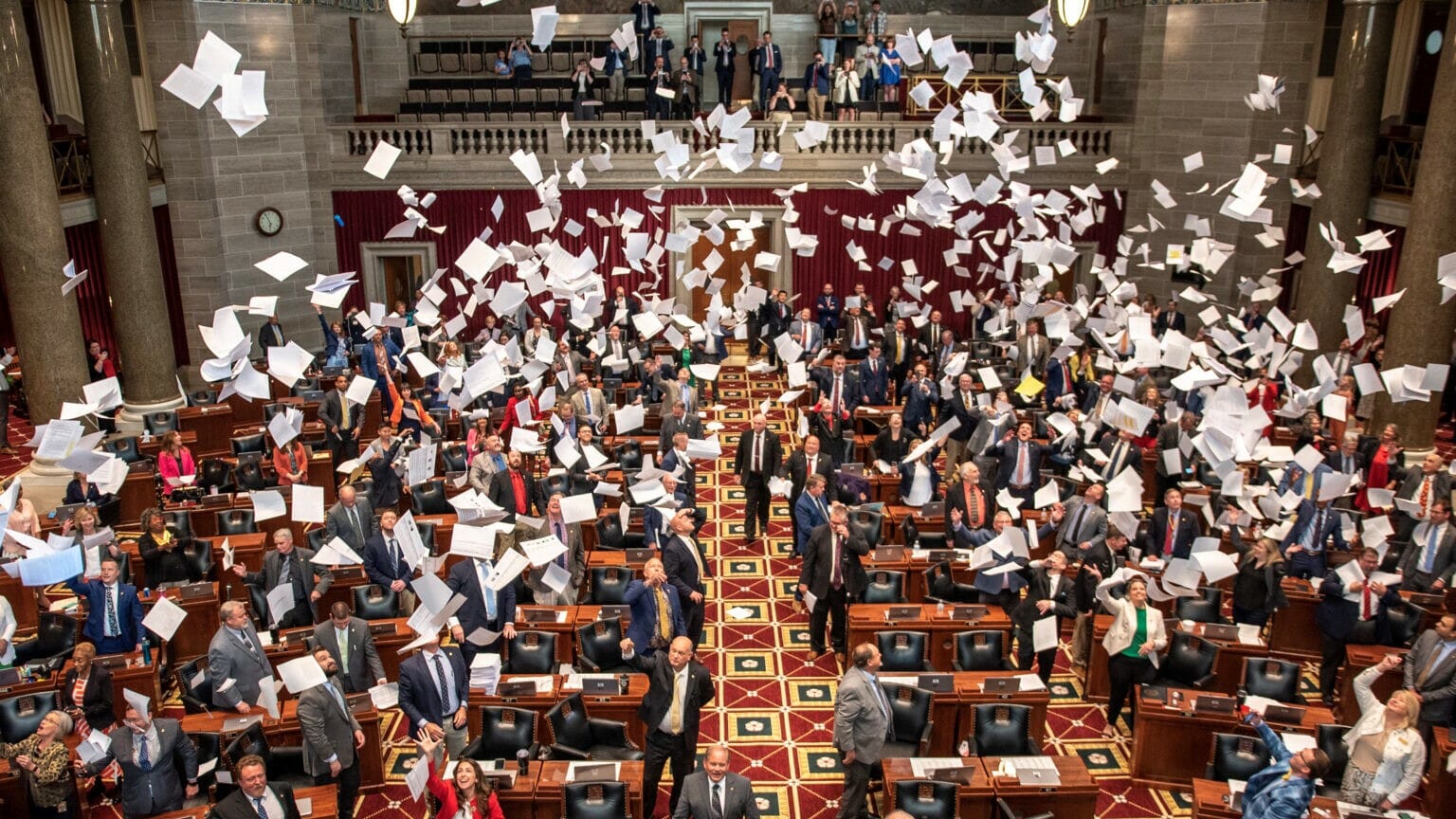 Members of the Missouri House throw paper into the air to celebrate the end of the 2023 legislative session.