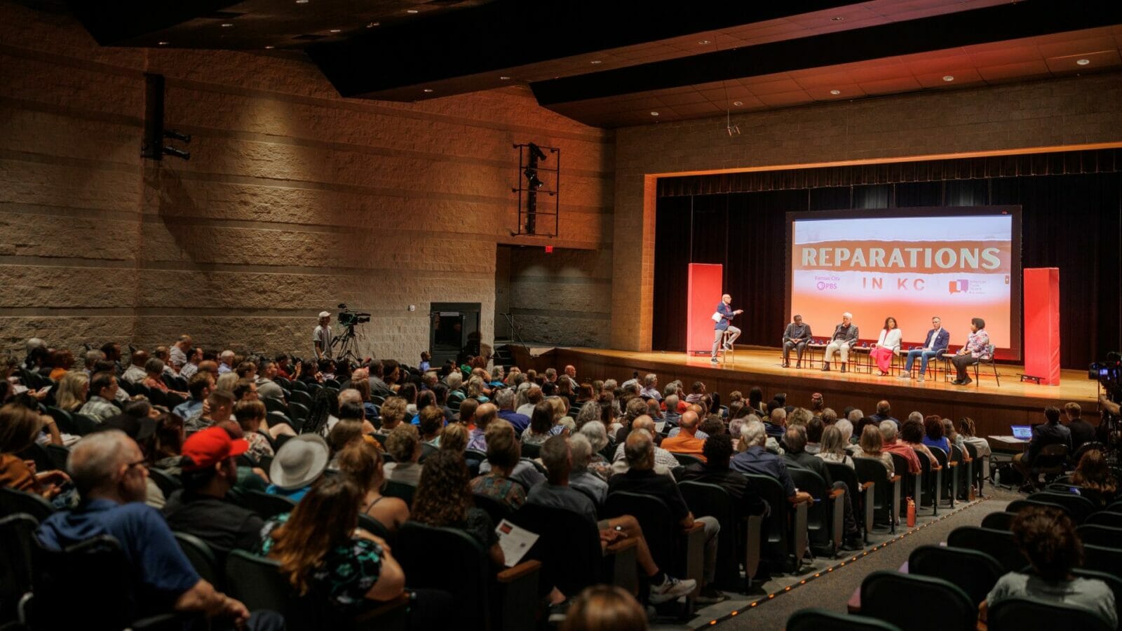 Hundreds of Kansas Citians gather at University Academy for a town hall discussion on reparations in Kansas City.