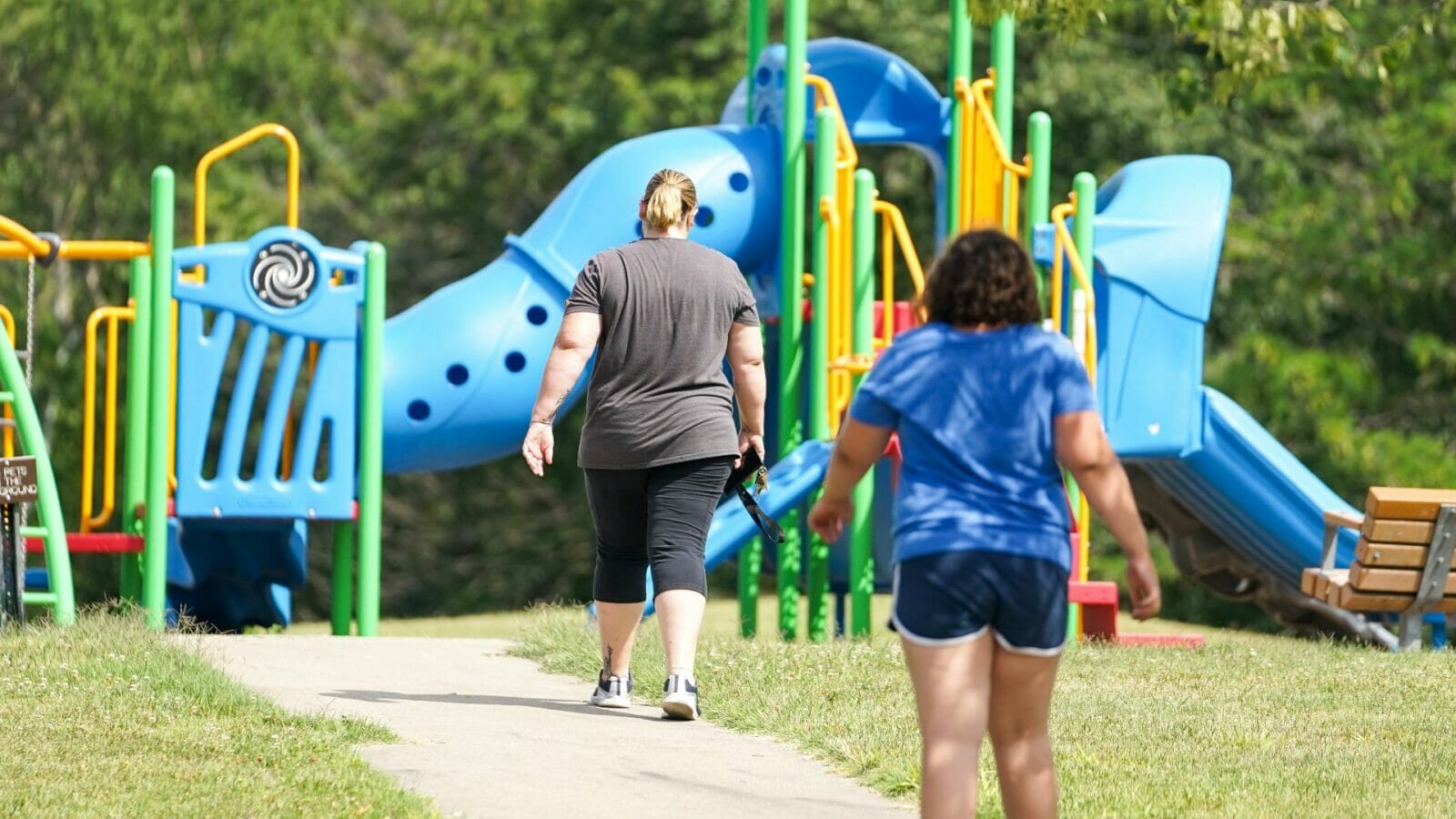 Becky Divine and her daughter, Evie, walk to a playground. Divine has more than $41,000 in student loans.