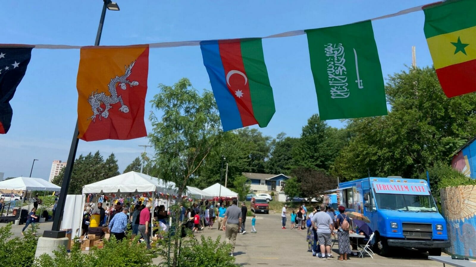 People, businesses and service organizations gather in a parking lot for Kansas City's World Refugee Day event.