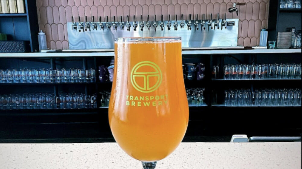 A glass of Transport Brewery beer on a bar.