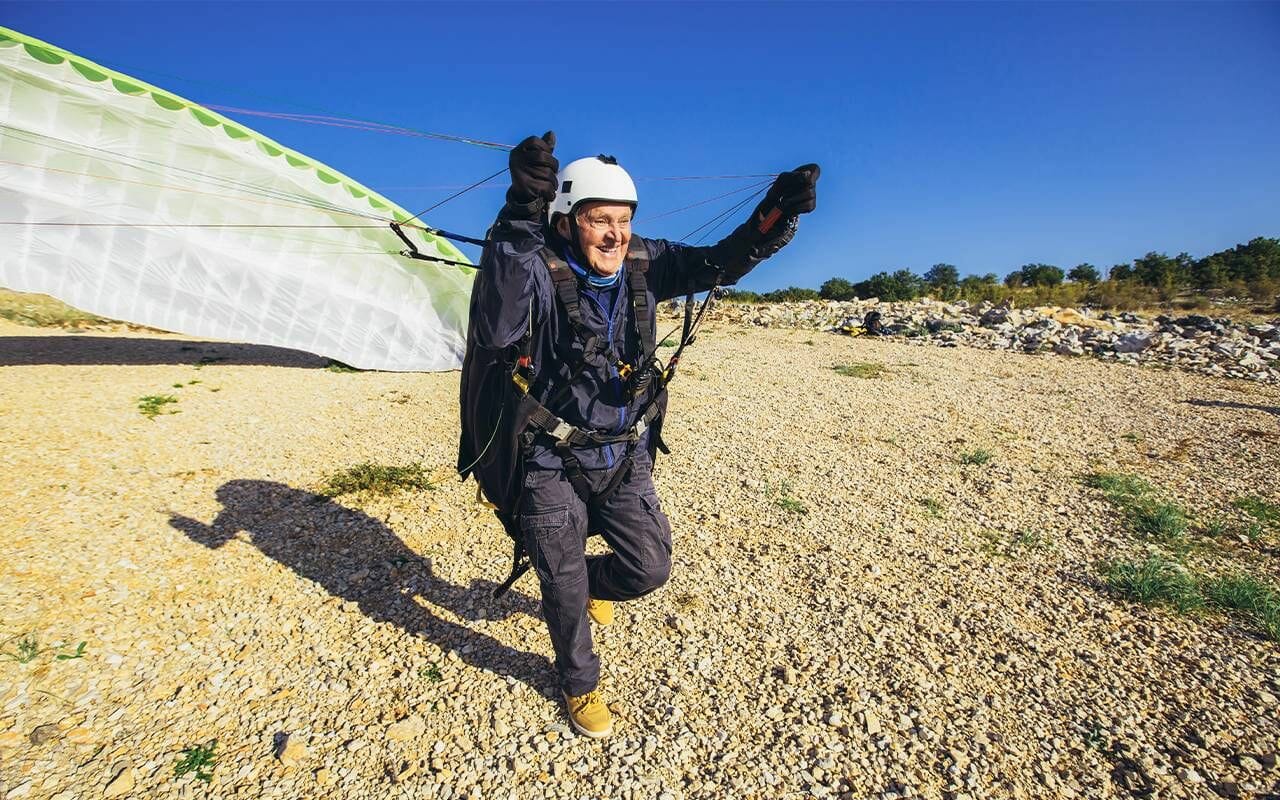Many older adults remain active. This person is pulling a parachute to base jump.