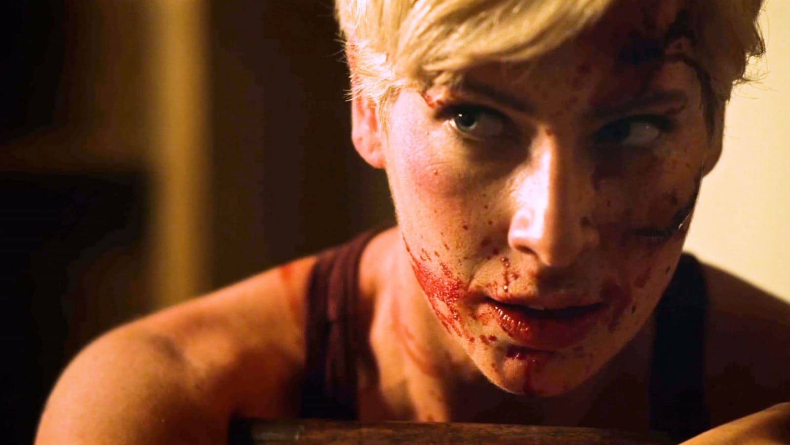 A scene from Patrick Rea's "They Wait in the Dark" shows a woman's blood-spattered face.