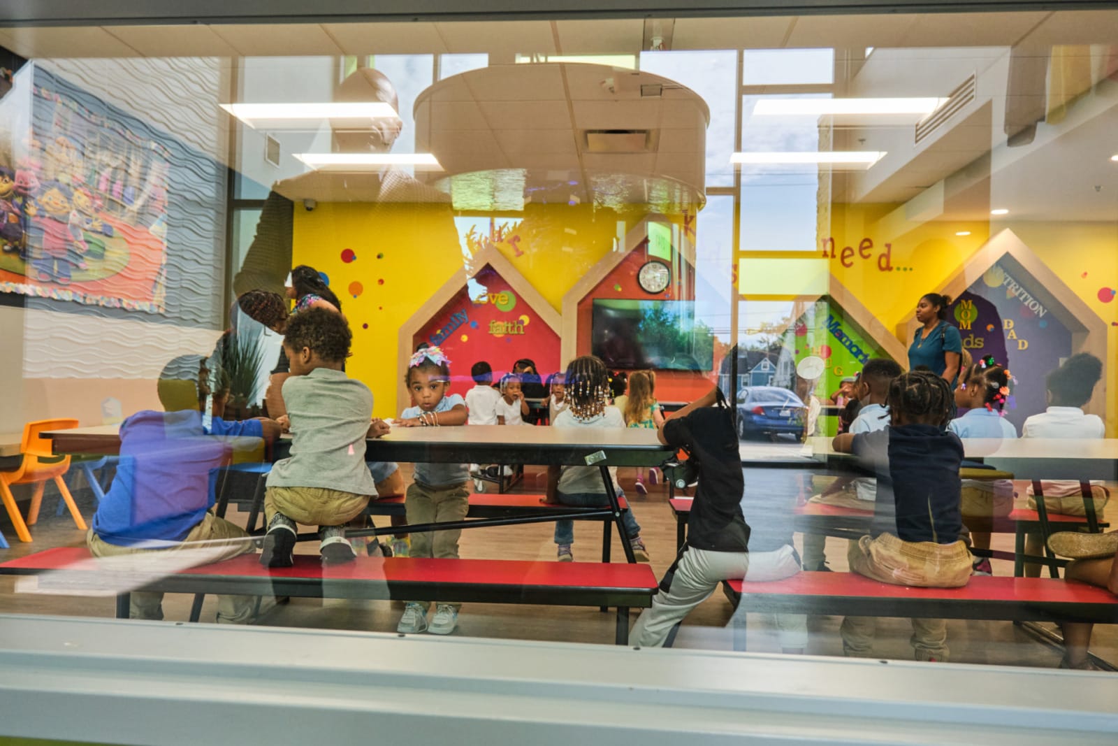 Founder Myron McCant looks through a window at the children served at KD Academy child care.