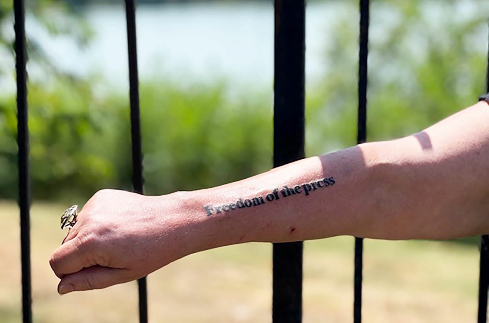 Freedom of the Press tattooed on a woman's forearm.