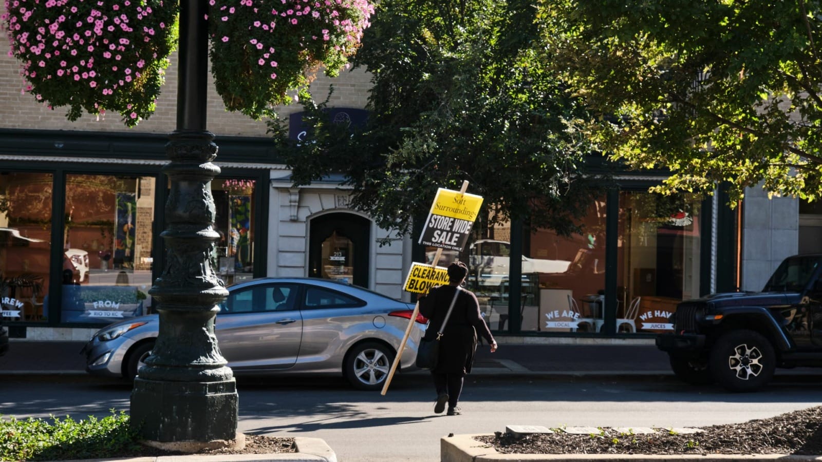 A worker carries a clearance sale sign on the Country Club Plaza.