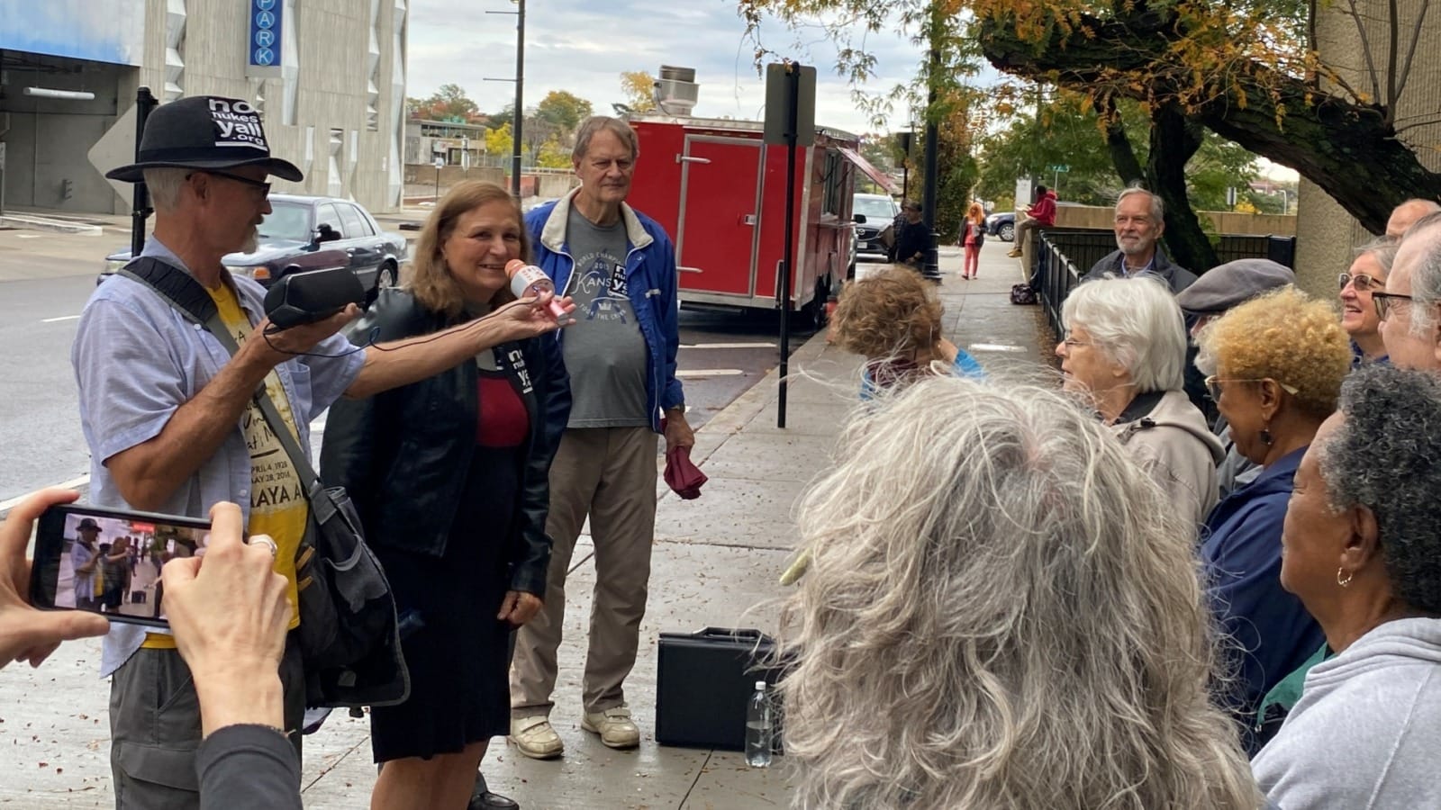 A group of anti-nuke activists gather on the sidewalk.