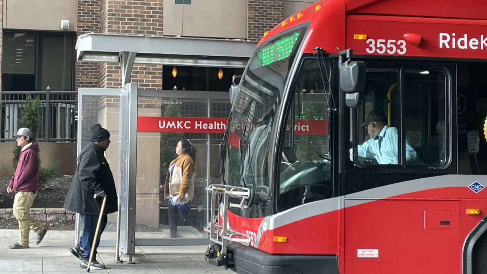 People at a bus stop at University Health.