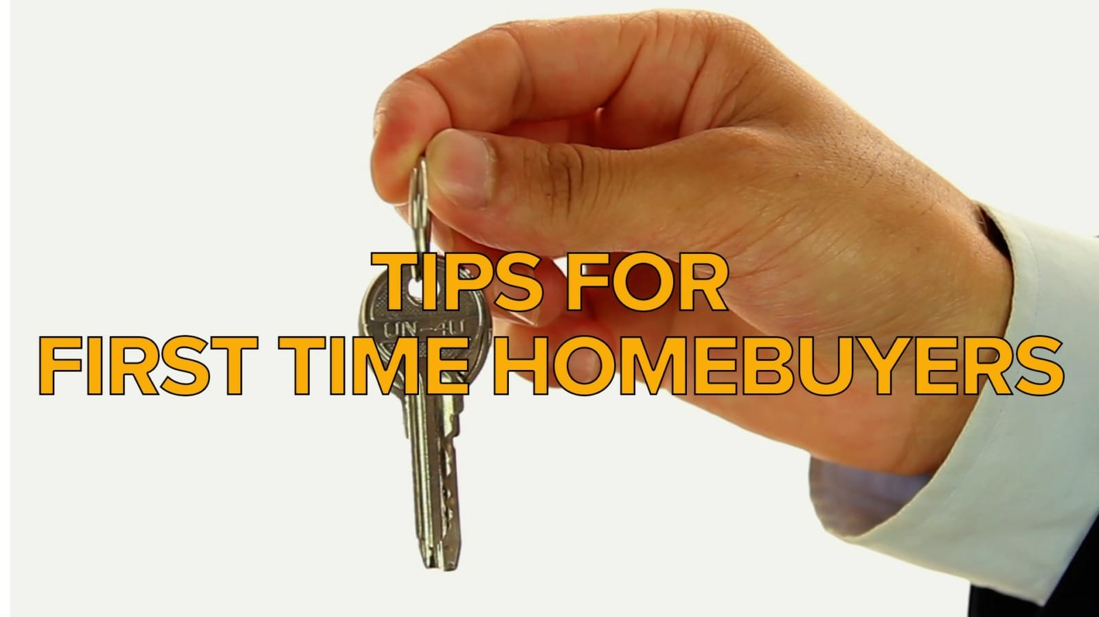 A hand holding keys to a house.