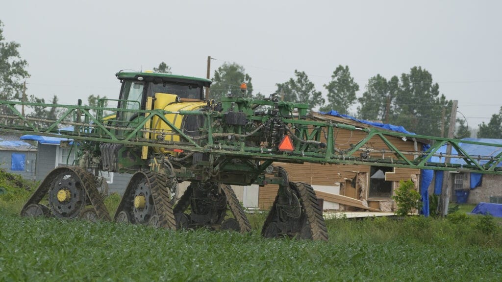 A farm tractor rolls along outside a Silver City, Miss., neighborhood in May. Mississippi lawmakers want the state to join the growing list of those regulating foreign ownership of agricultural land next year.