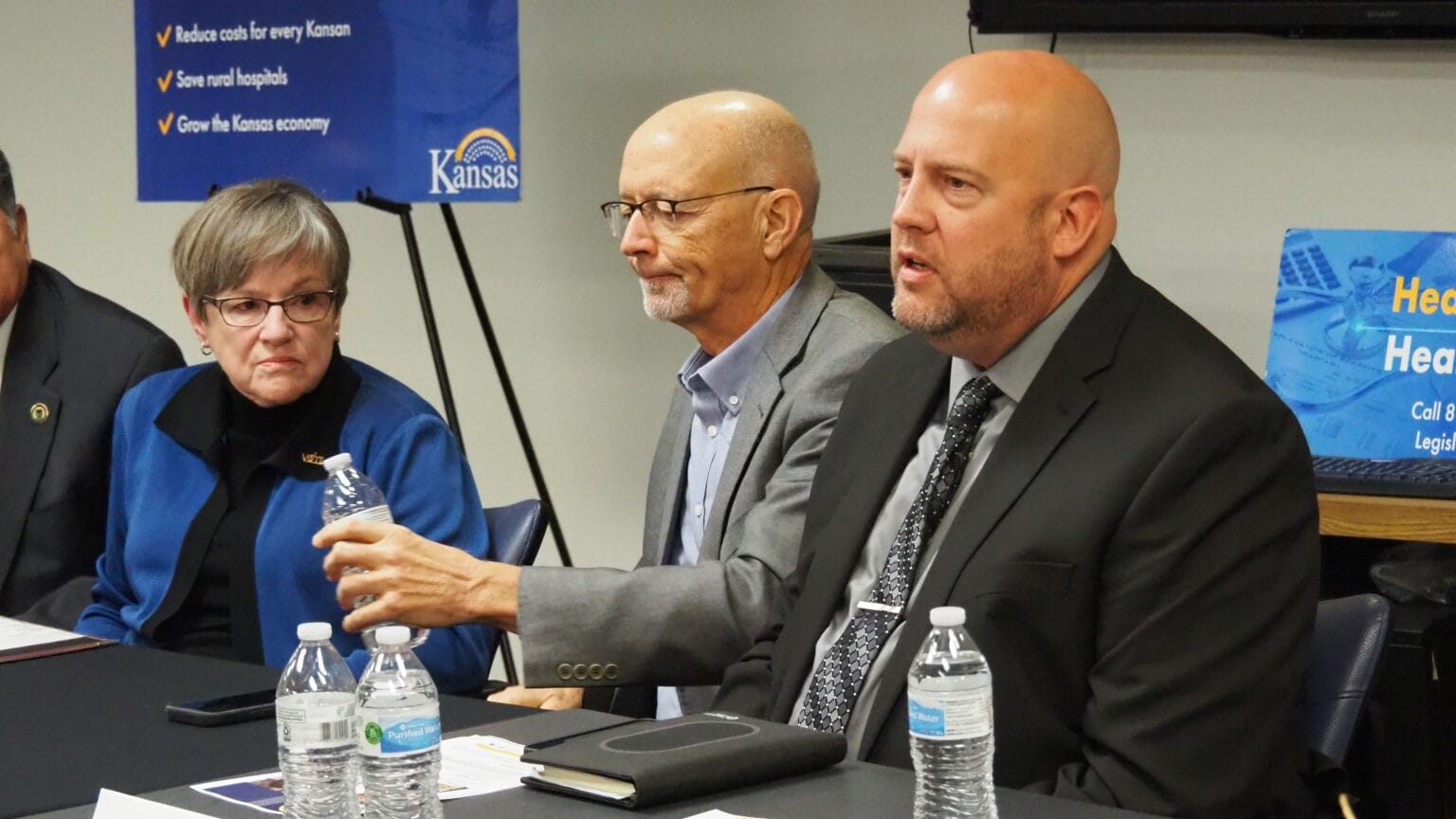 Gov. Laura Kelly, left, listens to a discussion about the advantage of expanding eligibility for Medicaid to lower-income Kansans as 40 states have done since 2014, including Missouri, Nebraska, Colorado and Oklahoma.
