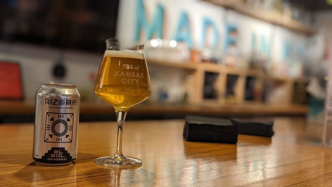 Rizoma beer in a glass and can on a bar.