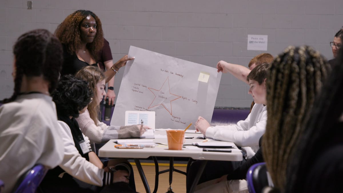 Students hold up a poster with a star in the middle and notes written all around it.
