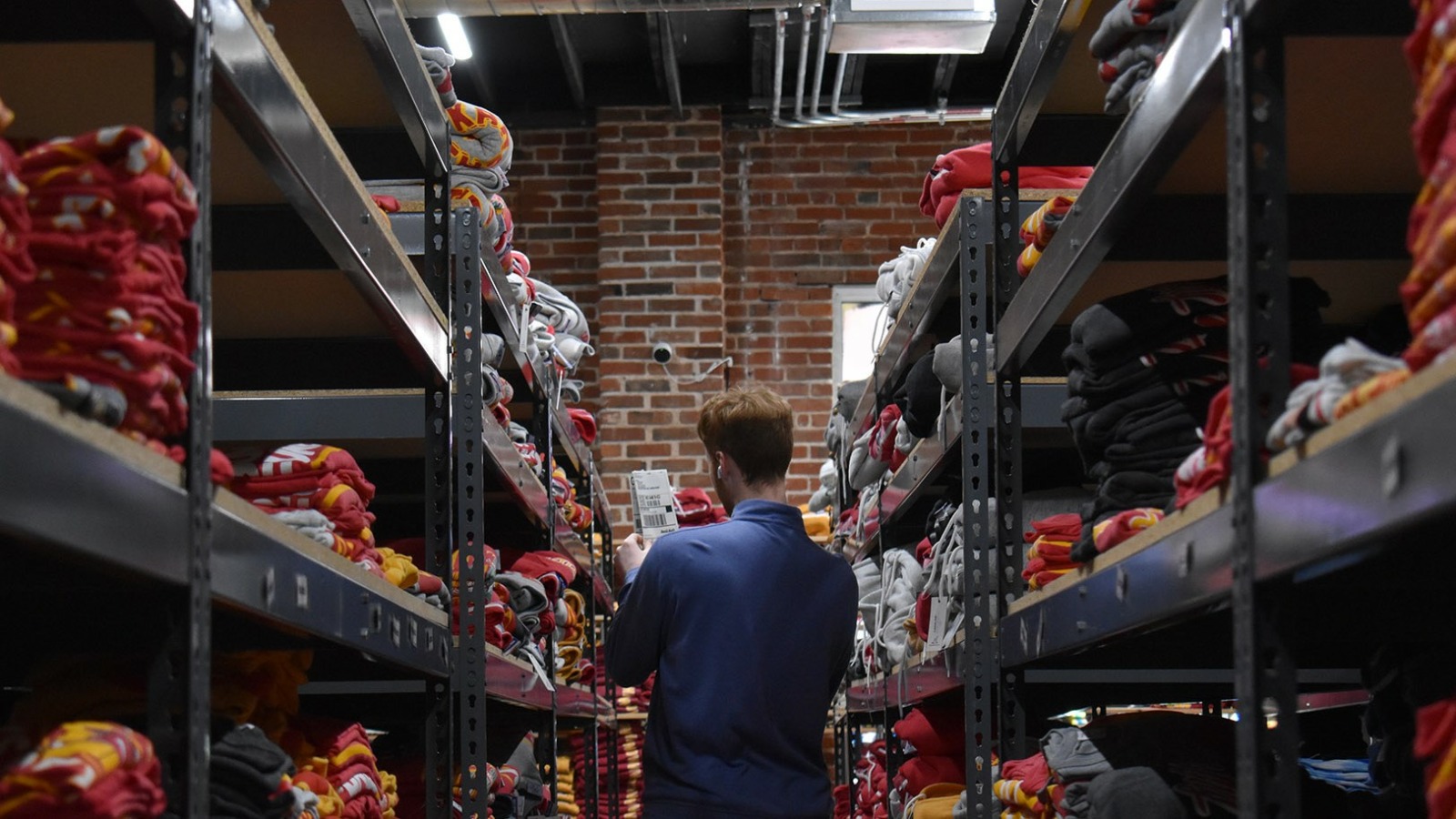A member of the Charlie Hustle team scans the Kansas City apparel brand's stock room for an item bound for an online order.