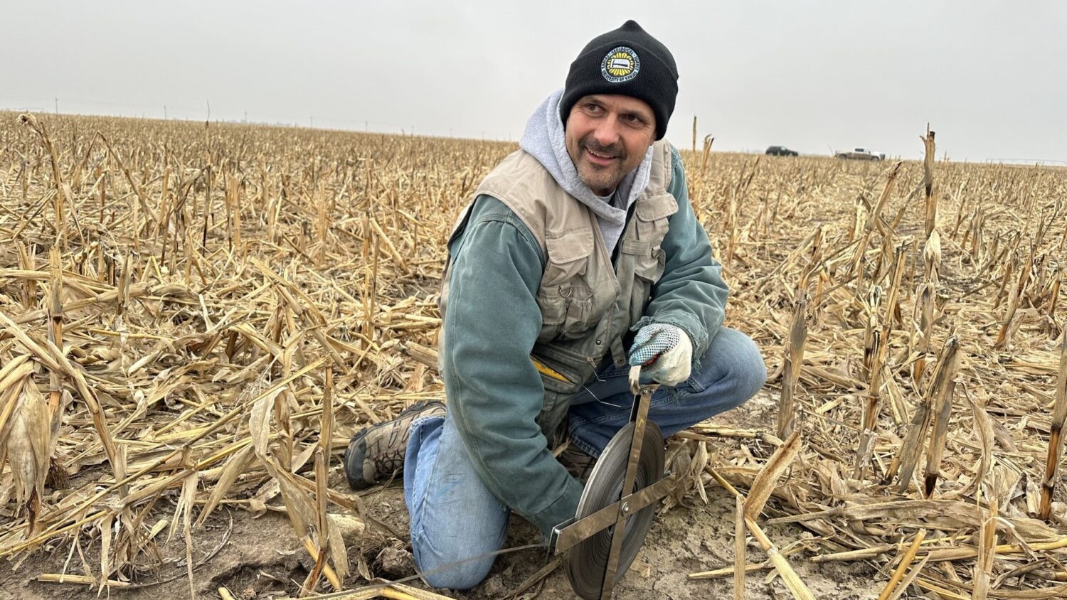 Brownie Wilson kneels next to a decommissioned irrigation well outside Moscow, Kansas.