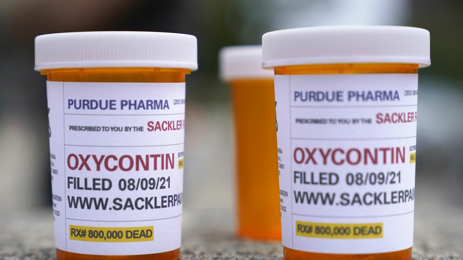Fake pill bottles with messages about OxyContin maker Purdue Pharma are displayed during a protest outside the courthouse where the bankruptcy of the company was taking place in White Plains, New York.
