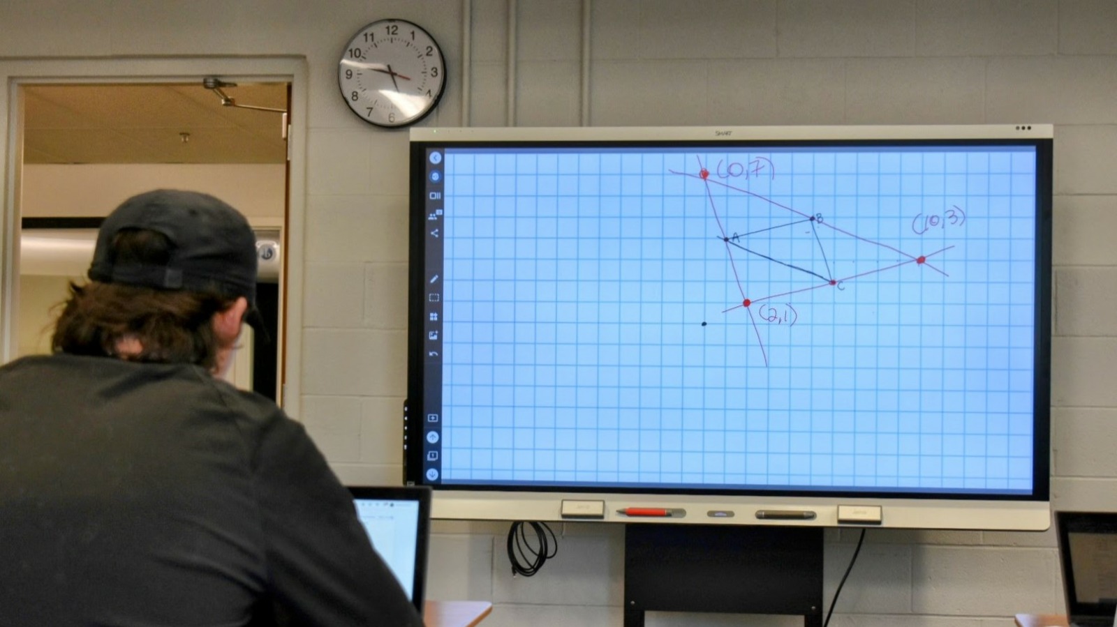 A student works on a math problem with the help of a laptop and smart board in Vetta Manning's summer school class at Lee's Summit High School on June 11.