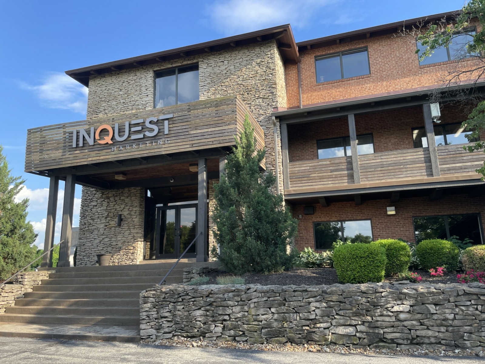Stone and brick building INQUEST lettering on front, concrete steps