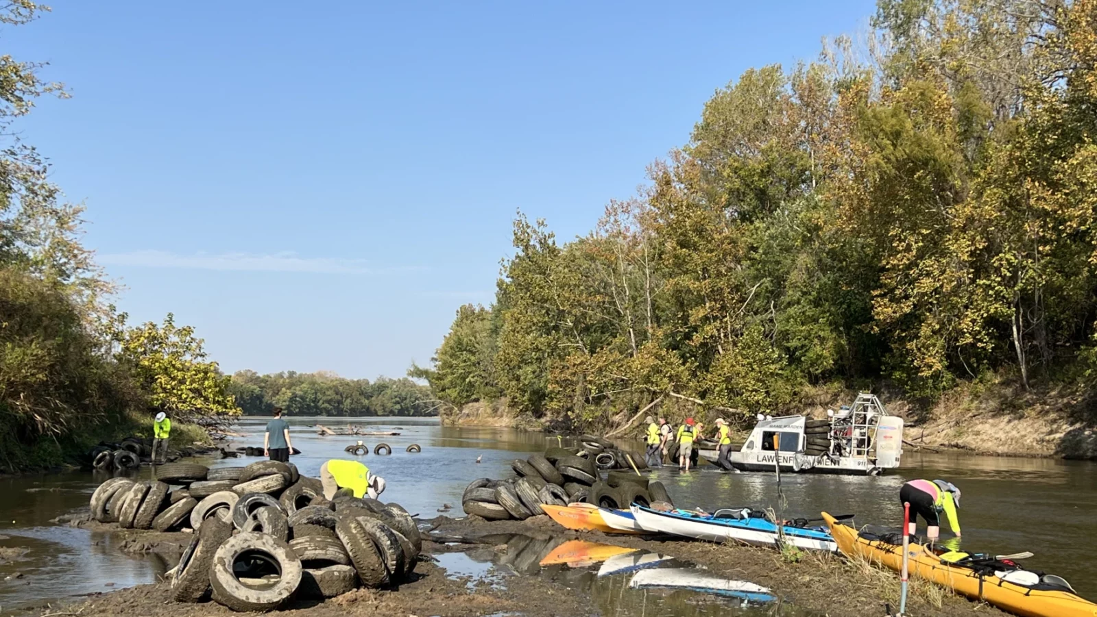Friends of the Kaw’s trained volunteers pull tires out of the Kansas River between Eudora and De Soto in October. A Kansas Department of Wildlife and Parks game warden helps ferry the tires away by boat.
