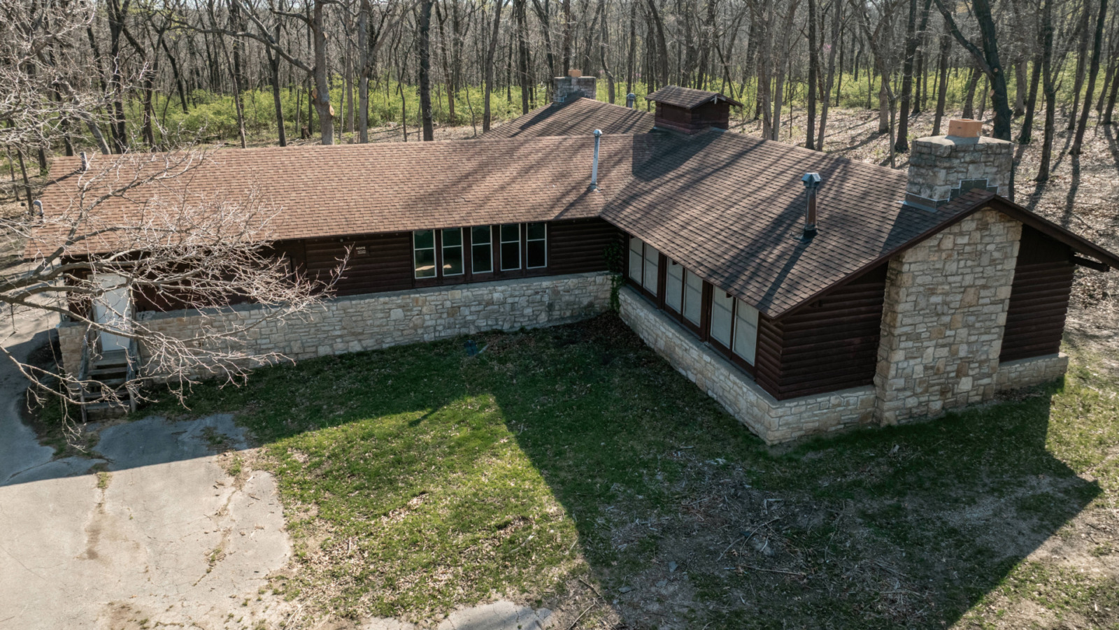 Spring growth surrounds Hope Lodge in Swope Park on April 08, 2025, in Kansas City, Missouri. Hope Lodge is the last functional building remaining from Camp Hope, a dilapidated summer camp within Swope Park. (Chase Castor | Flatland)