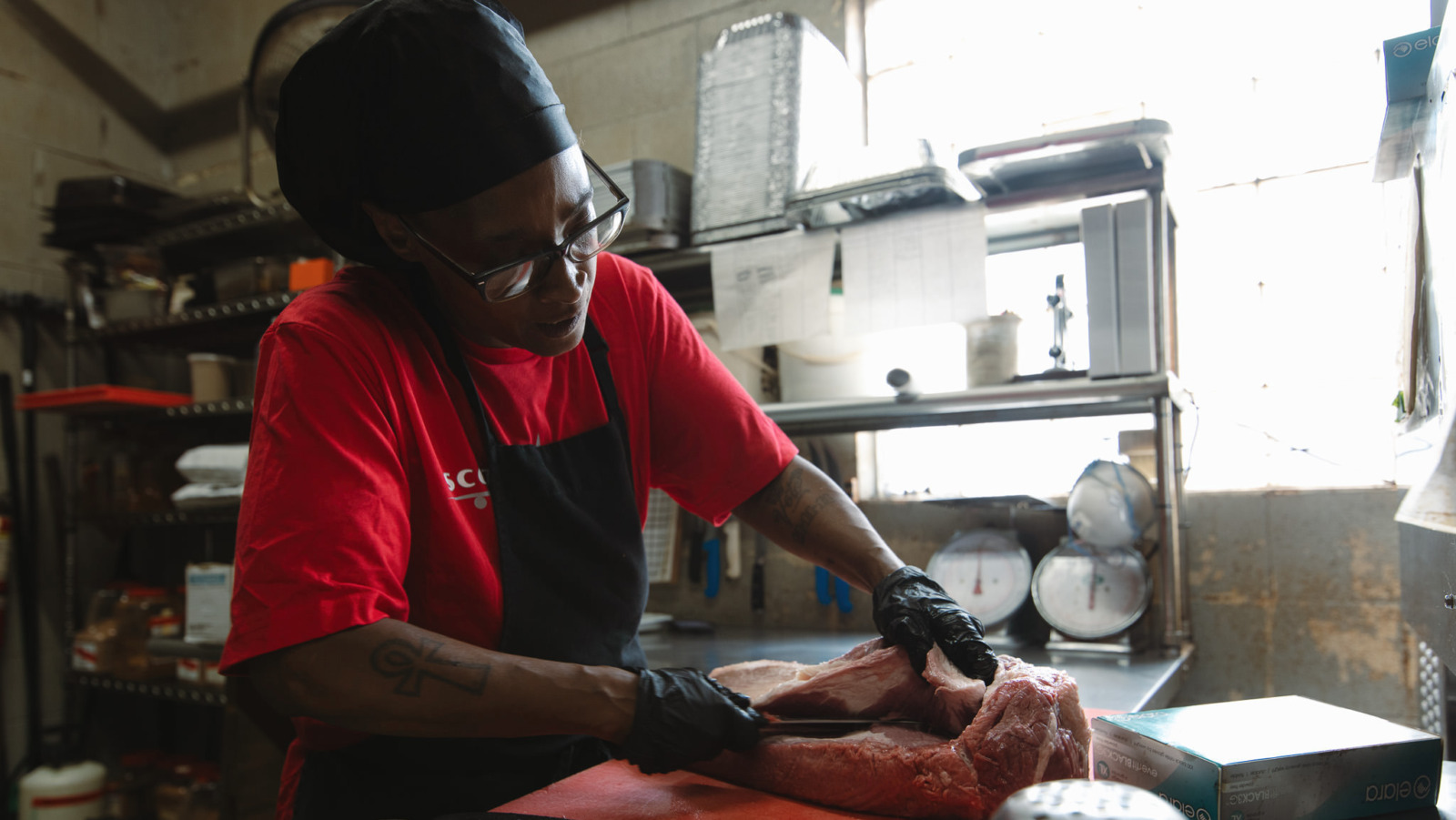 Veronica Scroggins trims beef for brisket at Scott’s Kitchen & Catering at Hangar 29 in Kansas City, North. (Chase Castor | Flatland)