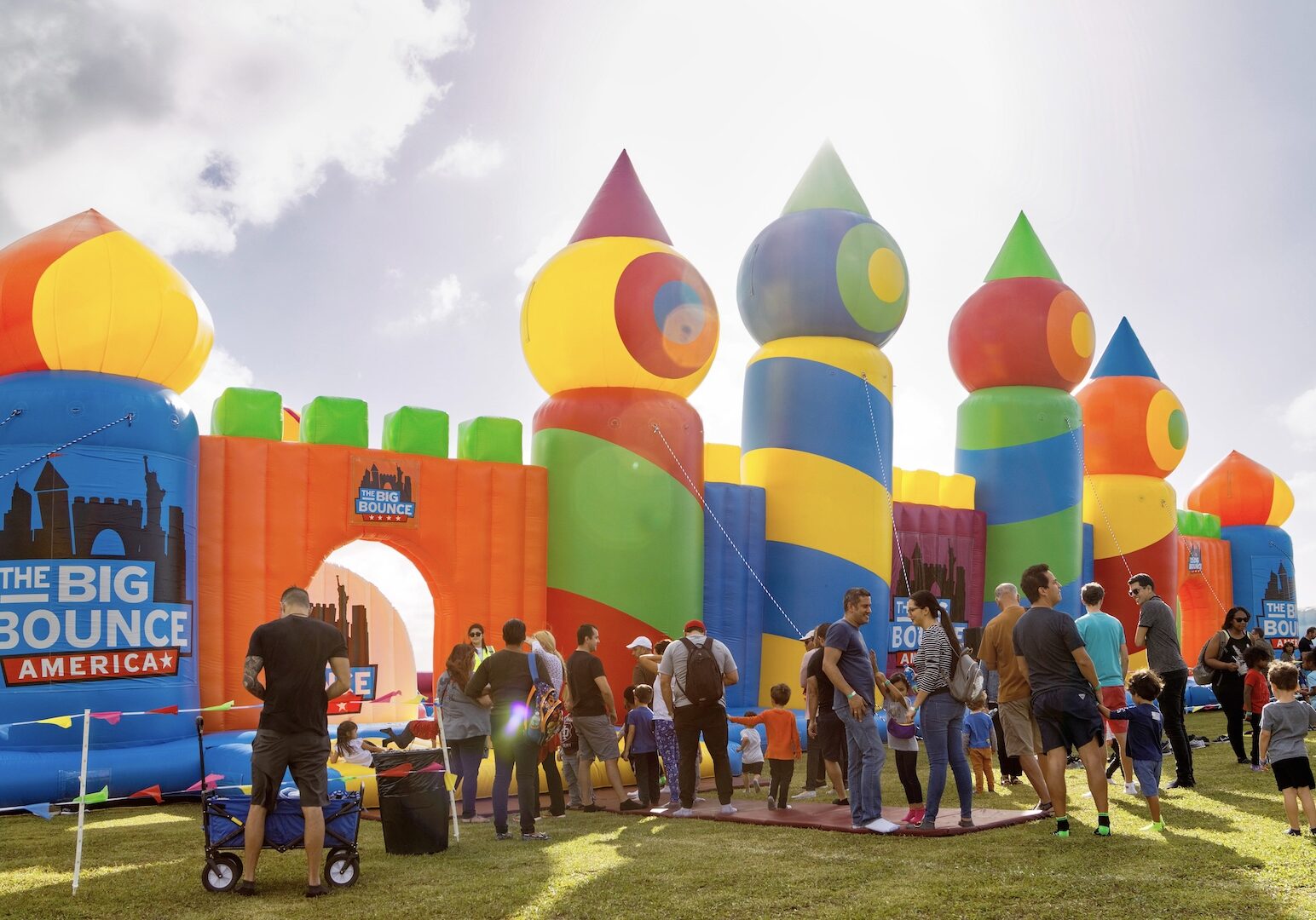 A huge inflatable bounce house with a line of people waiting to enter.