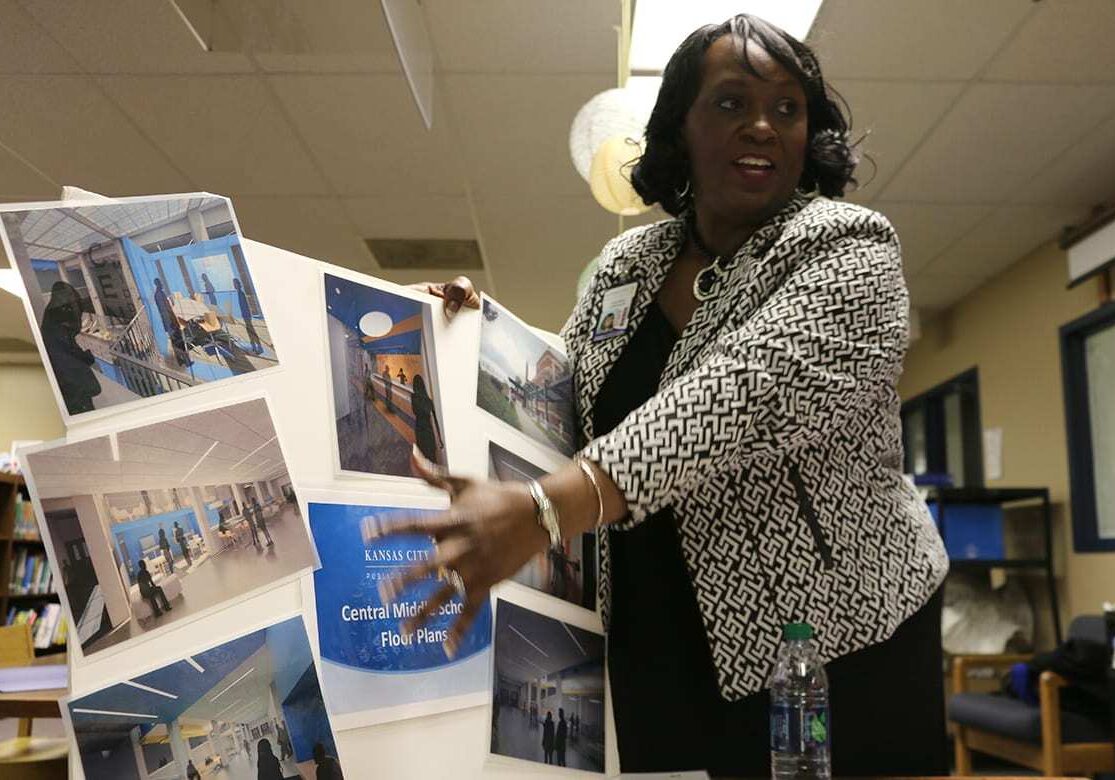 Picture of woman pointing to posterboard.