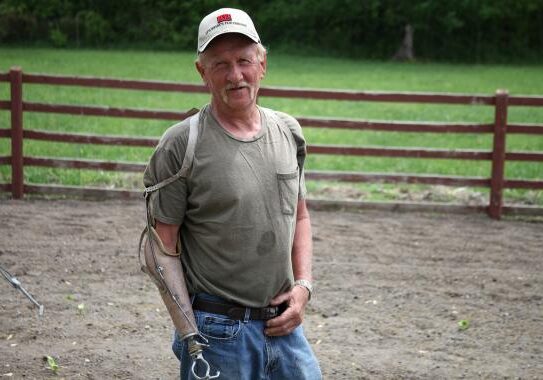 Farmer Brian Fleischmann in central Missouri lost part of his right arm in a harvest accident in 1996. Today he uses a farmer hook to help him with his work. (Kristofor Husted/Harvest Public Media)