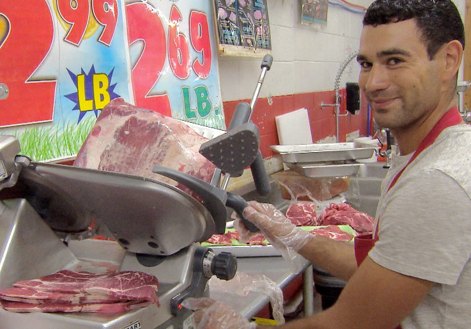 A grocery worker slices meat behind the counter at La Vazquez Market in Lexington, Neb. (Photo: Brian Seifferlein | Harvest Public Media)