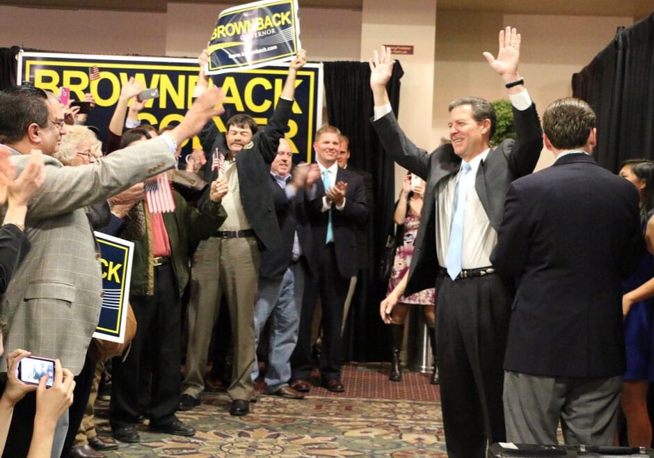 Governor Sam Brownback raising arms in front of crowd