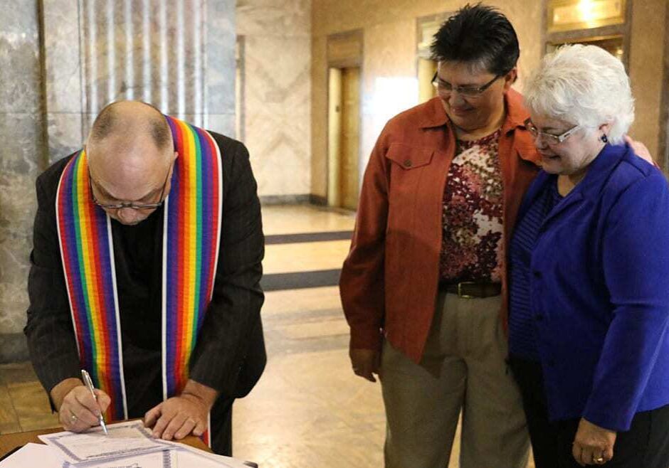 Rev. Kurt Krieger signing Terri Guillot's (middle) and Donna Botts' marriage license. (Photo by Bridgit Bowden/Hale Center for Journalism) 
