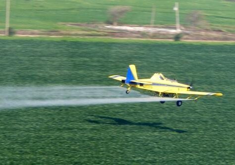 A pilot for Earl’s Flying Service sprays chemicals on a field in southeastern Missouri. (Photo courtesy of  Mike Lee)
