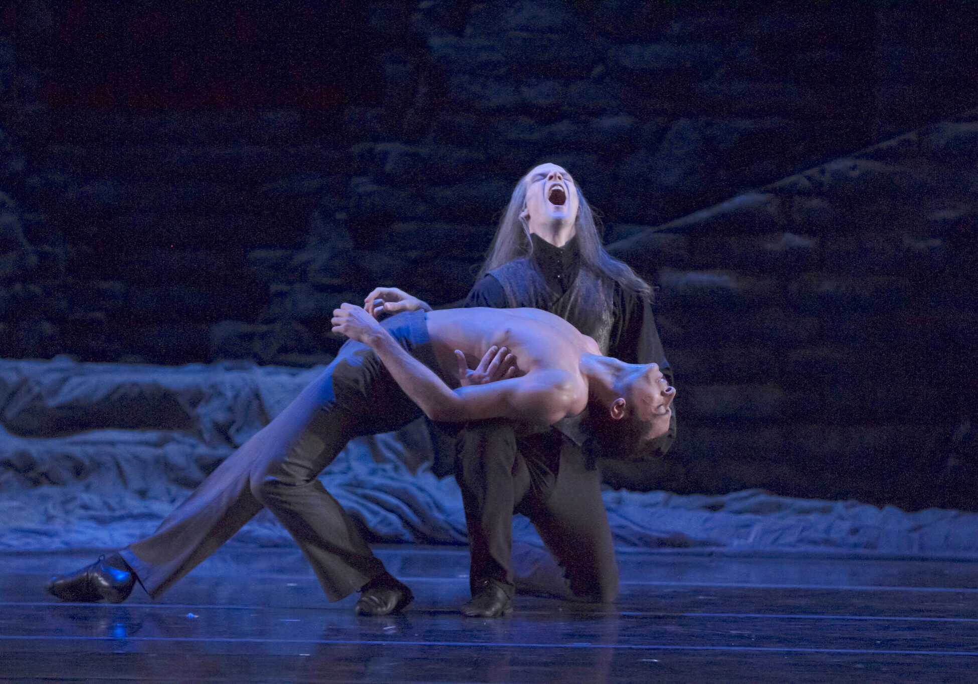 Dancers pose dramatically on stage.
