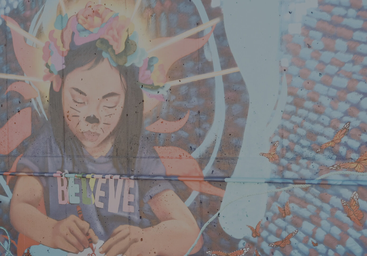 Section of mural with girl in Believe shirt